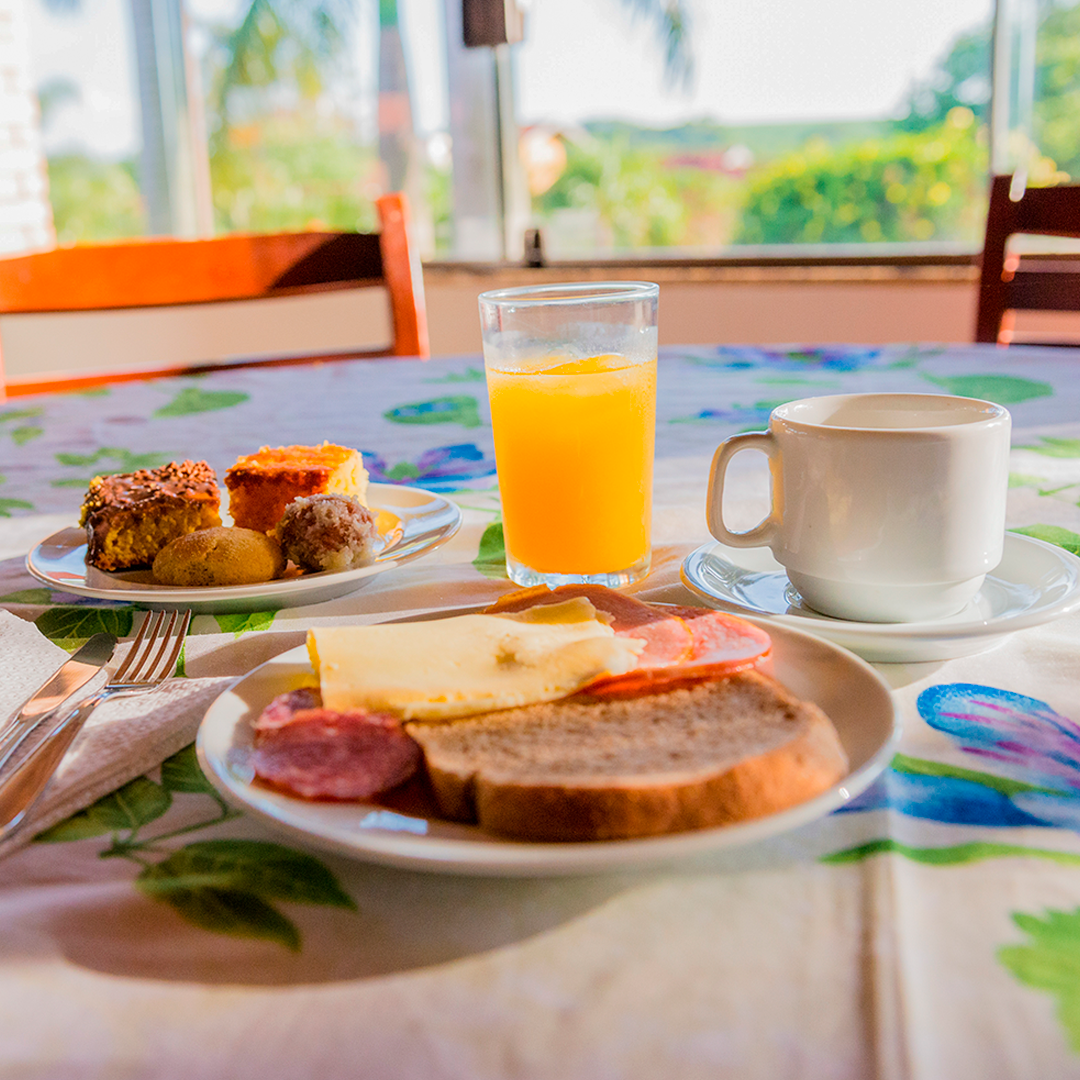 Café da manhã completo com pães, bolos, suco e café